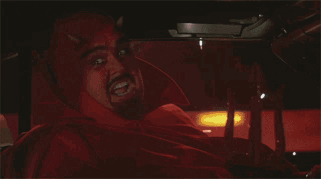 a man dressed in a devil costume is sitting in a car