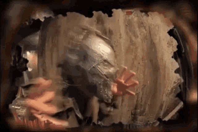 a person 's hand is sticking out of a hole in a wooden wall