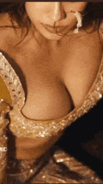 a close up of a woman 's breasts in a gold dress
