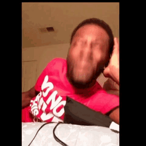 a man wearing a red shirt that says king is making a funny face