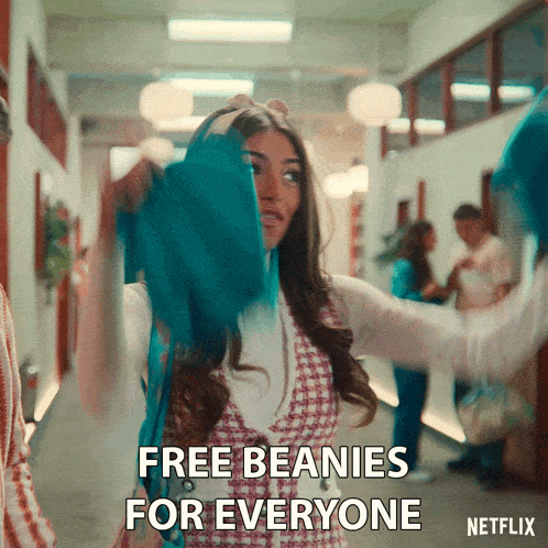 a woman in a hallway with the words free beanies for everyone written on the bottom