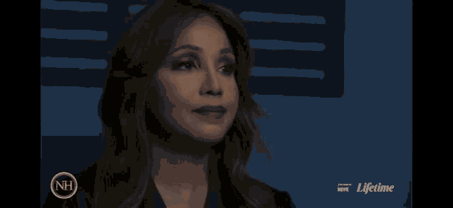 a woman in a dark room with a nh logo on the bottom
