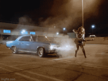 a woman playing a guitar in a parking lot