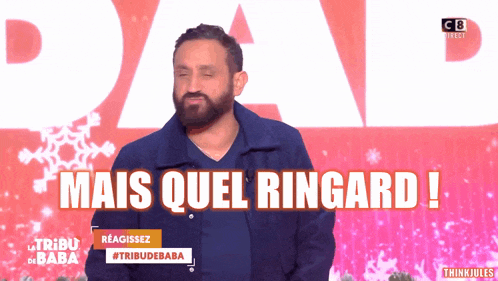 a man with a beard stands in front of a sign that says mais quel ringard