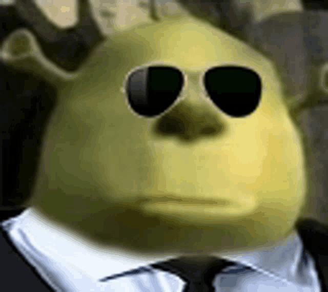 a shrek wearing sunglasses and a suit and tie .