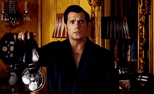 a man in a robe is holding a pair of shoes .
