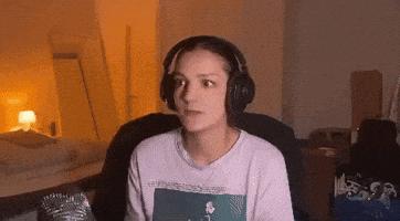 a woman wearing headphones is sitting in a chair looking at the camera .