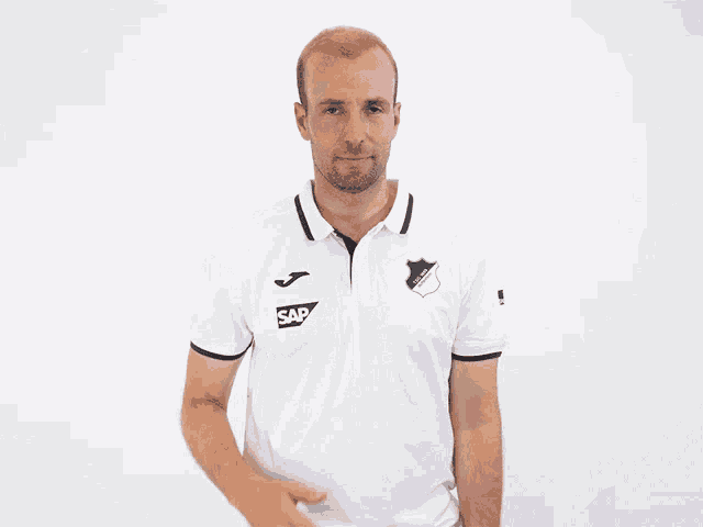 a man wearing a white shirt with sap on the front