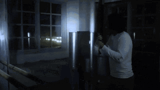 a person is standing in a dark room holding a light