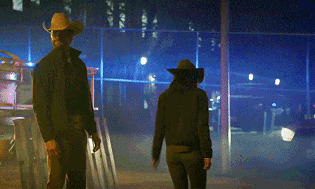 a man in a texas ranger jacket is walking with a woman