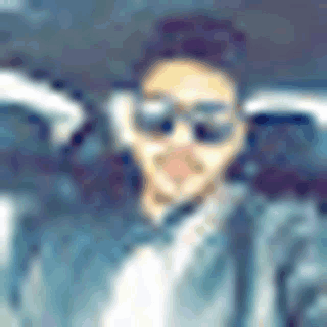 a blurry picture of a man wearing sunglasses and a suit .