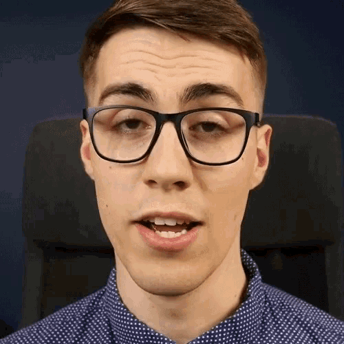 a man wearing glasses and a blue shirt is making a face