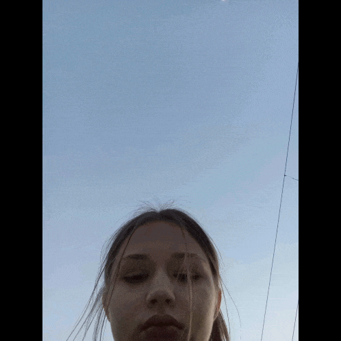 a girl taking a picture with a blue sky in the background