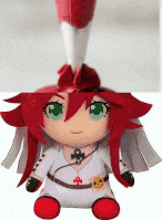 a stuffed doll with red hair and green eyes is sitting down .
