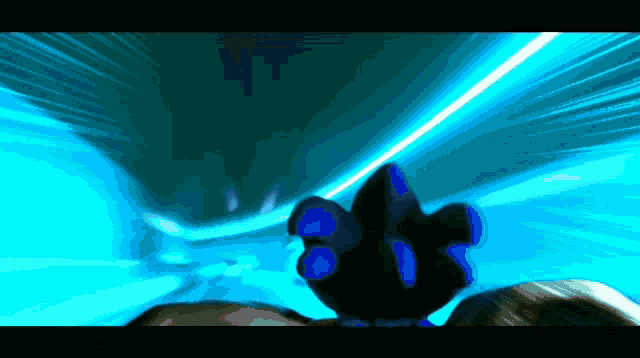 a person 's hand is reaching out towards a blue light beam