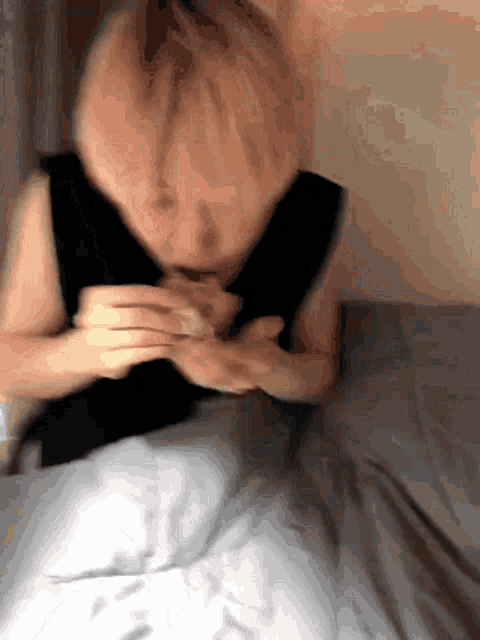 a blurry picture of a woman laying on a bed eating something