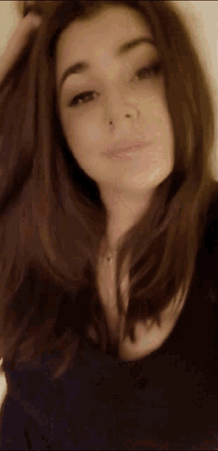 a blurry picture of a woman 's face with her hand in her hair