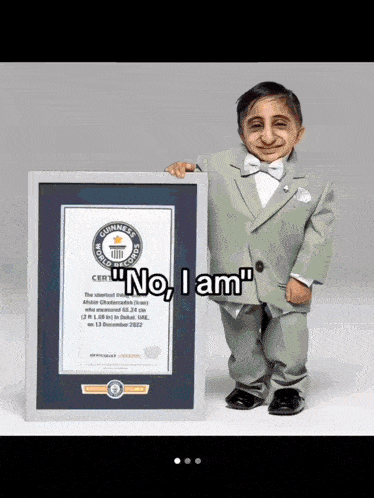 a man in a suit and bow tie is holding a guinness world record certificate