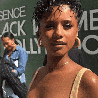 a woman stands in front of a sign that says sence black and ally