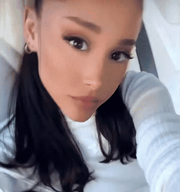 a close up of a woman taking a selfie with her hand on her chin .