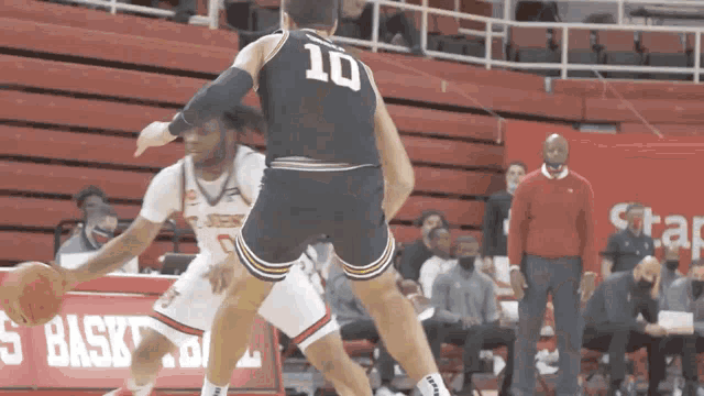 a basketball player with the number 10 on his jersey dribbles the ball