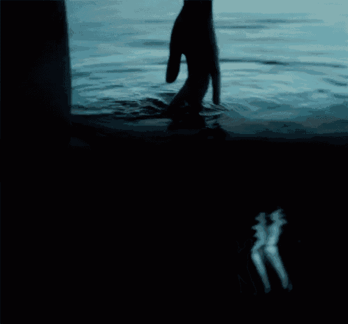 a person 's hand is reaching out into the water