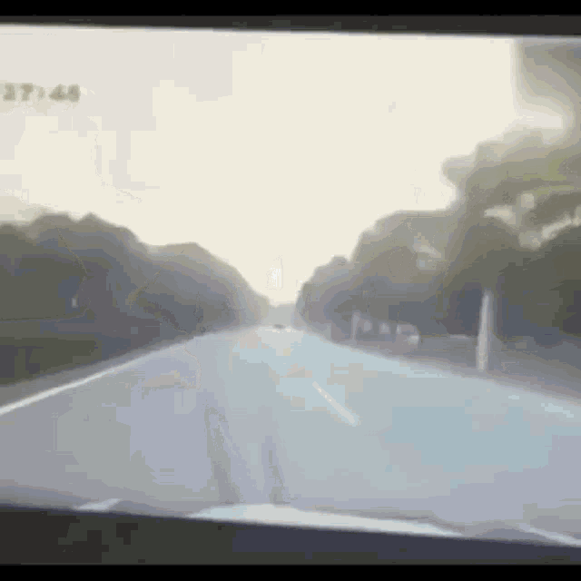 a car is driving down a highway with the time of 7:44