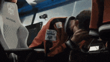 a man is sitting in a chair with his head down and his hands on his face .