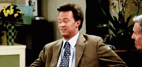 a man in a suit and tie is sitting at a table with another man .