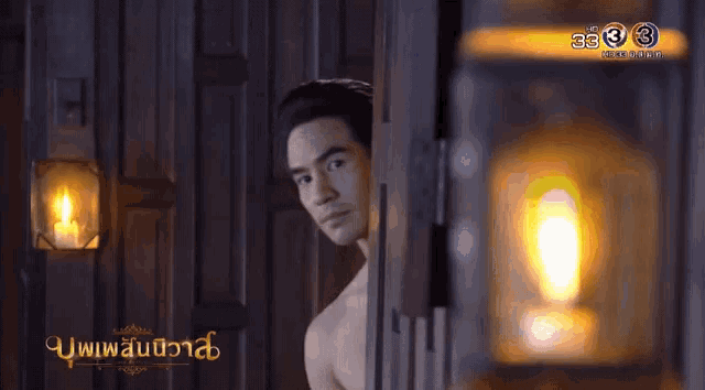 a man without a shirt is standing in a dark room with a lantern and the number 3 on the bottom