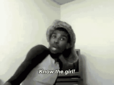 a man wearing a fur hat is standing in front of a television in a room .