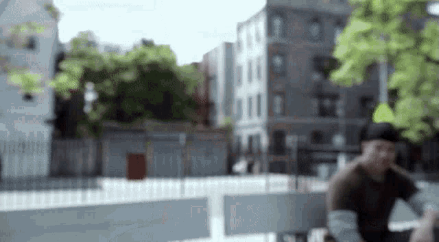 a blurry picture of a man sitting on a bench in front of a building .
