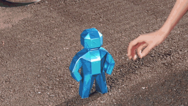 a person is holding a blue statue of a person