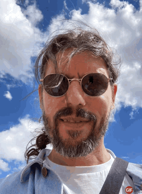 a man with a beard wearing sunglasses and a ponytail