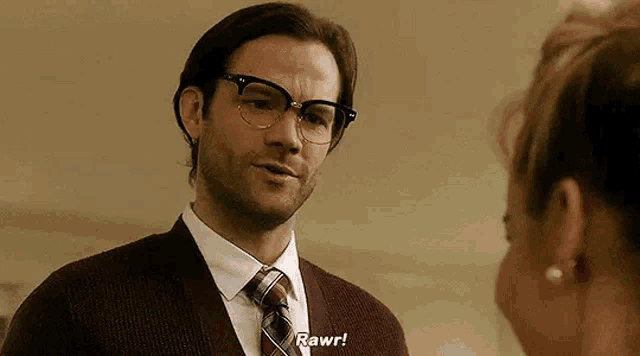 a man wearing glasses is talking to a woman .
