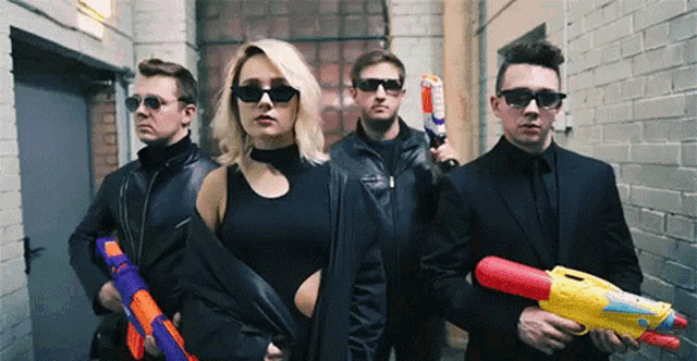 a group of men and a woman holding water guns