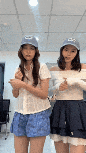 two women wearing hats that say ' la dodgers ' on them