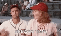 a man and a woman are standing next to each other on a baseball field . the woman is wearing a red hat .