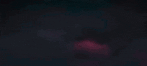 a close up of a red light coming out of a dark background .