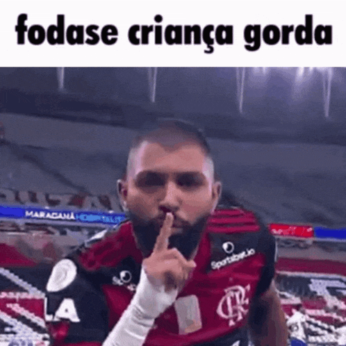 a man with a beard is making a silence gesture with his finger on his lips .