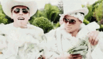 two men in cowboy hats and sunglasses are holding a bag of money .