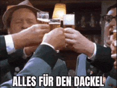 a group of men are toasting with beer in a bar and the words alles fur den dackel are above them .