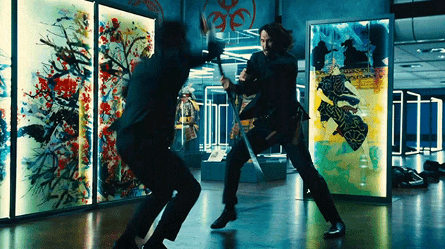 a man in a suit is fighting another man in front of paintings