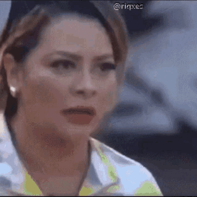 a woman is making a funny face while wearing a yellow shirt .