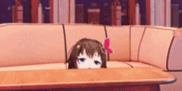 a girl peeking out from behind a couch in a living room .