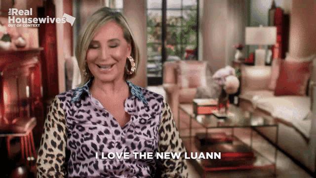 a woman in a leopard print shirt says " i love the new loann "