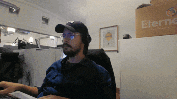 a man wearing headphones sits at a desk in front of a box that says eternal