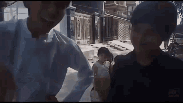 a group of people are standing next to each other on a sidewalk .