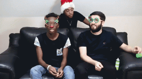 a man wearing a santa hat and glasses sits on a couch