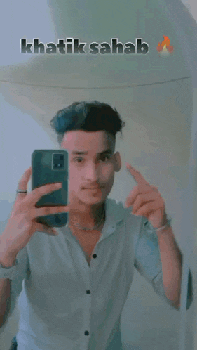 a young man is taking a picture of himself in the mirror with his phone .